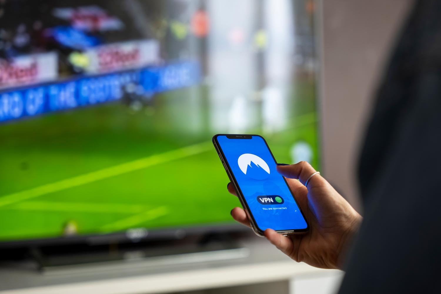 Persona configurando una VPN en su smartphone para ver streaming en la televisión.